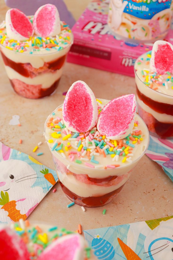 three desserts with bunny ears and sprinkles in them on a table