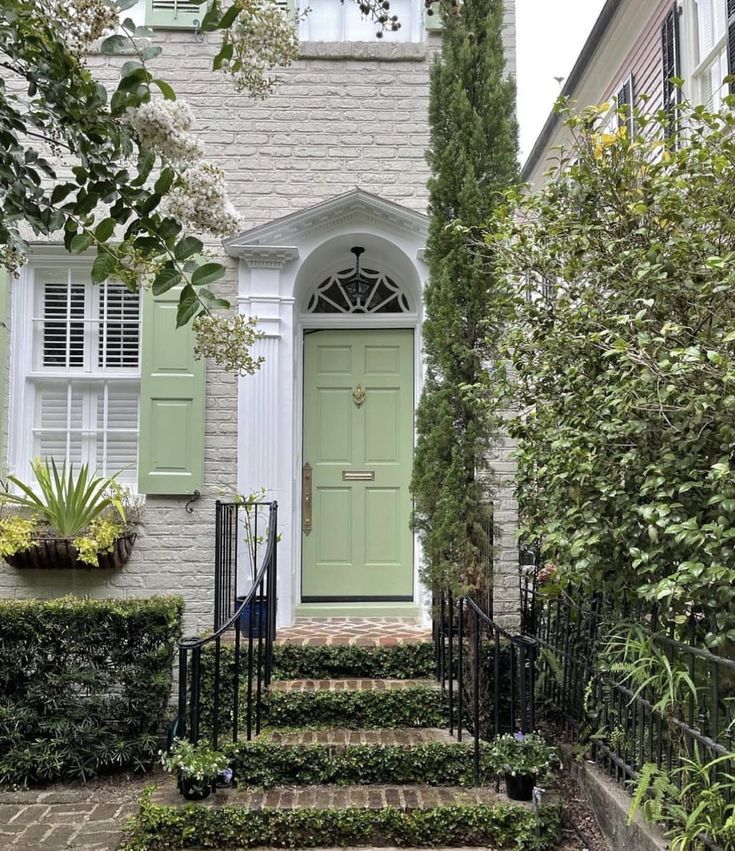 a house with green doors and brick steps