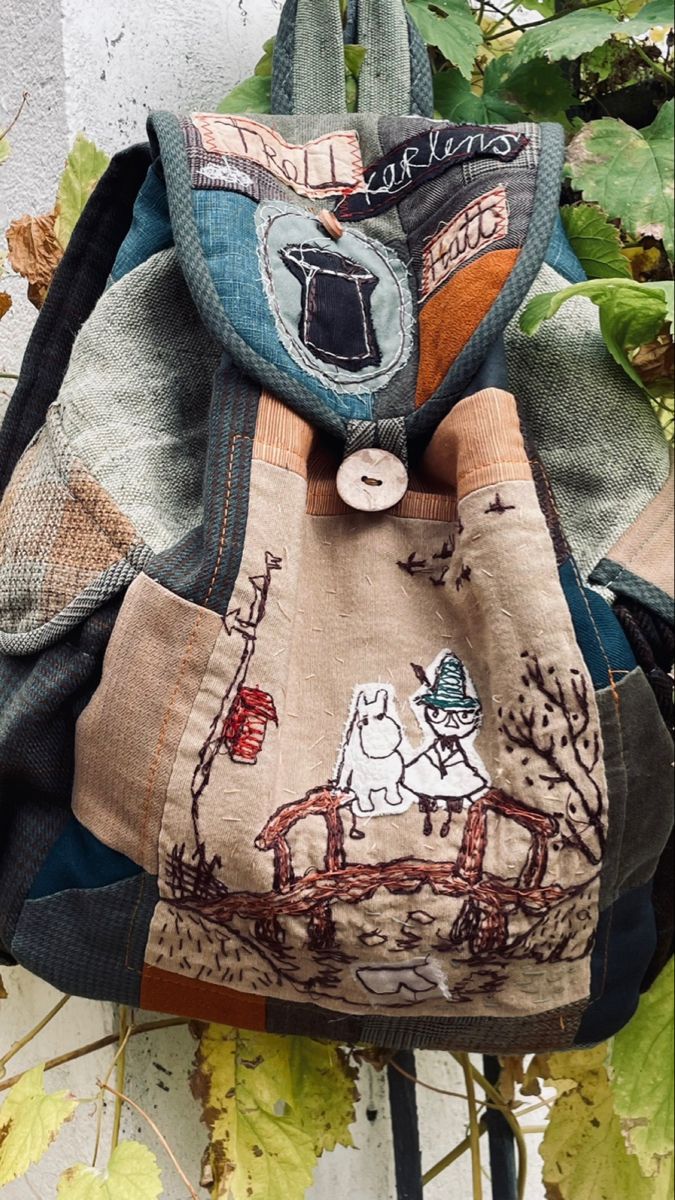 the back of a backpack with an animal design on it, hanging from a tree