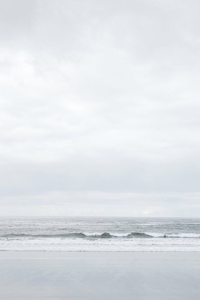 two surfers walking on the beach with their surfboards