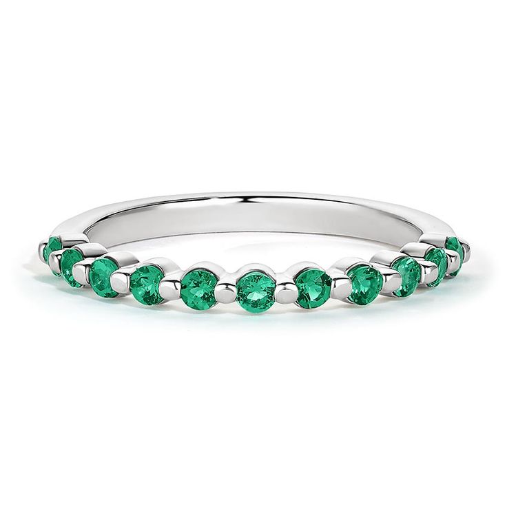 a white gold band with green stones