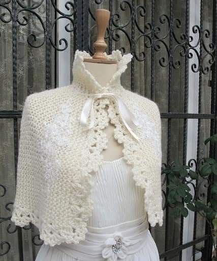 a white crocheted jacket on top of a mannequin