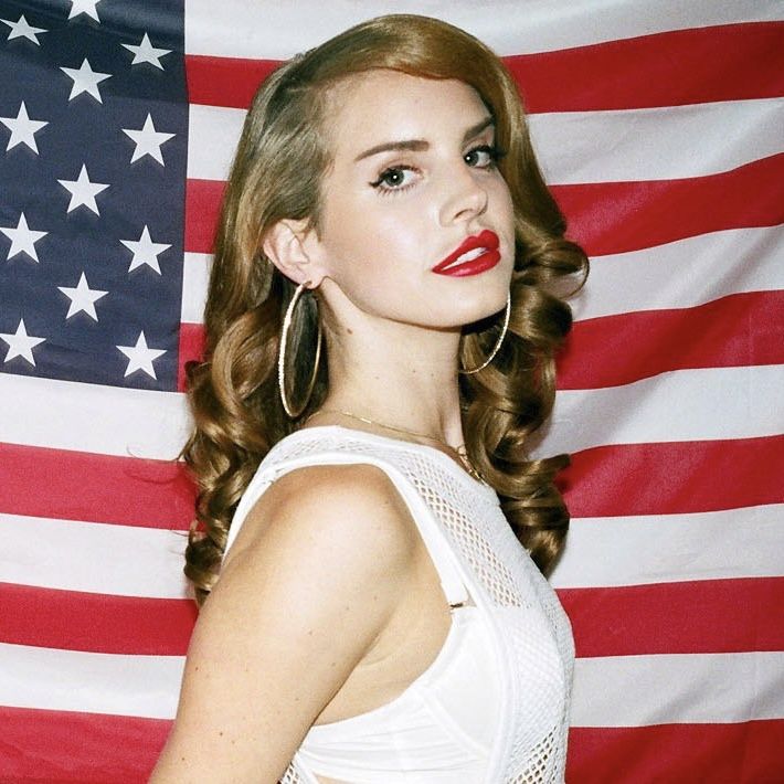 a beautiful young lady standing in front of an american flag with red lipstick on her lips