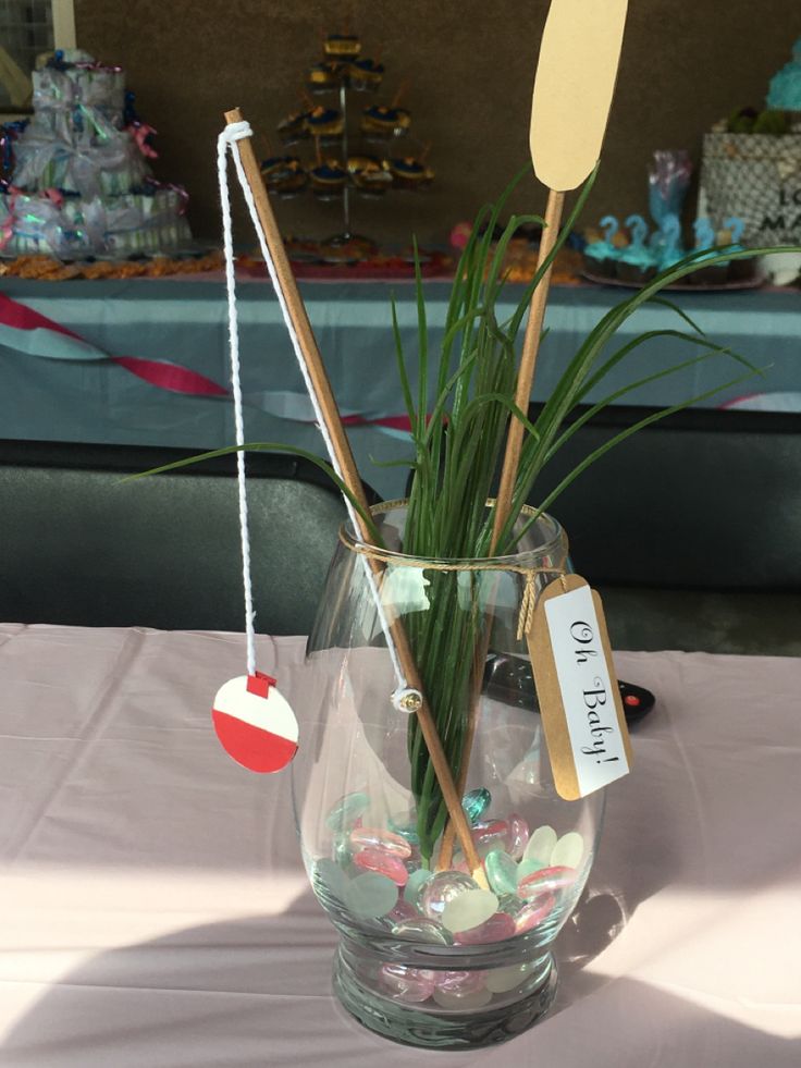 a vase filled with plants and candy on top of a white tablecloth covered table