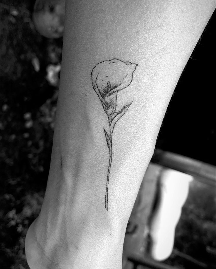 a single flower tattoo on the left foot is shown in this black and white photo