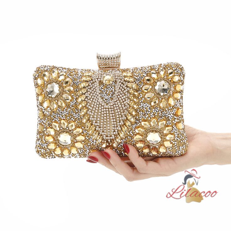 Possessing a handbag like this is a true testament to your exquisite taste and love for luxury. This dazzling clutch is designed to be the centerpiece of any glamorous ensemble. Its surface is encrusted with meticulously placed crystals and gems, creating a radiant, eye-catching effect that sparkles with every movement. The intricate floral patterns made from golden stones add a layer of sophistication and timeless elegance. The top clasp is equally adorned, ensuring that every detail of this ha Embellished Crystal Clutch For Evening, Embellished Crystal Evening Bag For Formal Occasions, Embellished Crystal Evening Clutch, Formal Embellished Crystal Evening Bag, Elegant Evening Bag With Crystal Bling, Glamorous Handheld Evening Bag With Rhinestones, Crystal Evening Bag With Rhinestones, Elegant Crystal Evening Bag With Bling, Elegant Crystal Bags With Rhinestones