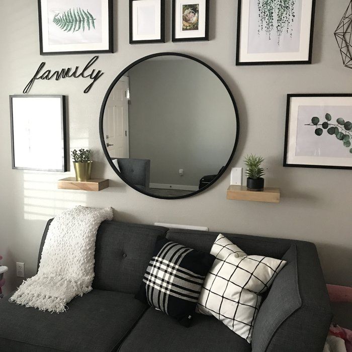 a living room filled with furniture and framed pictures on the wall above it's mirror