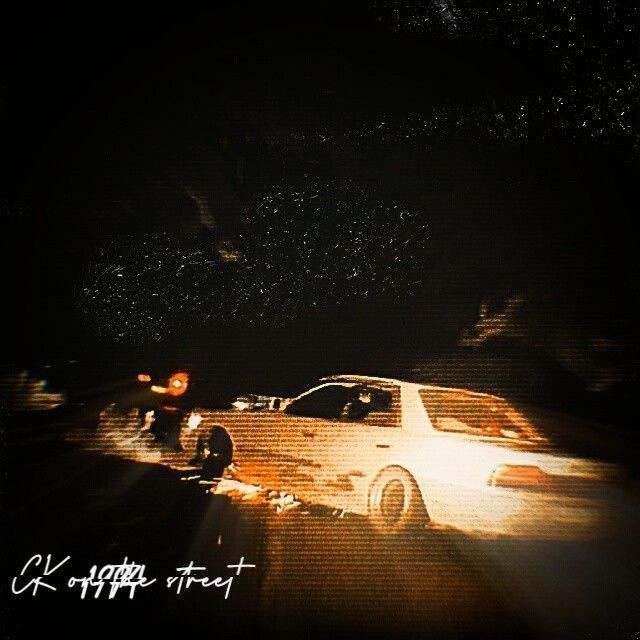 a white car parked on the side of a road at night