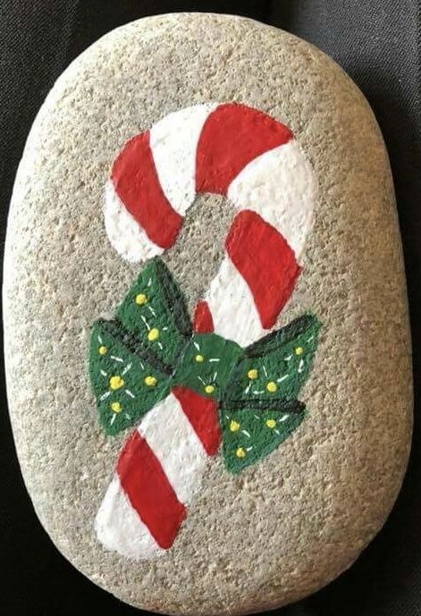 a painted rock with candy canes on it