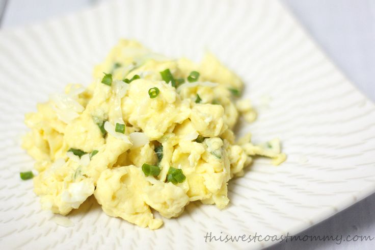 scrambled eggs with green onions on a paper plate