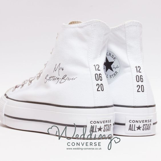 a pair of white converse sneakers with writing on them