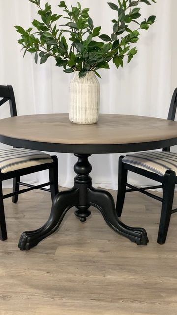 a potted plant sitting on top of a table next to two chairs and a vase