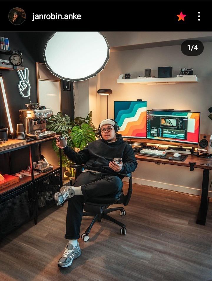 a man sitting in a chair with his feet up on the desk and holding a remote control