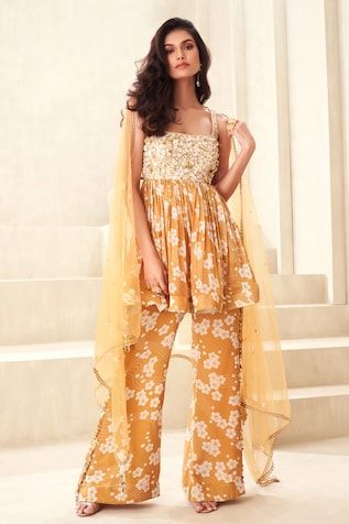 Gold floral print peplum top with floral embroidered yoke and back tie-up. Paired with a flared print pant and embellished dupatta. - Aza Fashions Festive Floral Print Peplum Set, Designer Sleeveless Sets With Printed Motifs, Fitted Peplum Sharara For Spring, Sleeveless Spring Designer Palazzo Set, Sleeveless Spring Palazzo Set For Designer Wear, Spring Sleeveless Designer Palazzo Set, Spring Designer Sleeveless Palazzo Set, Sleeveless Sets With Printed Motifs, Spring Embroidered Sleeveless Palazzo Set