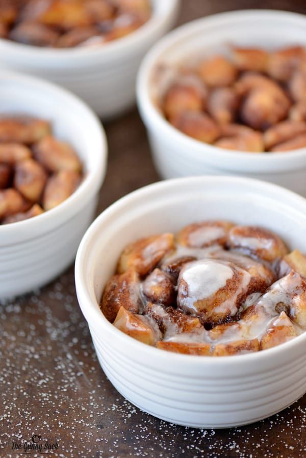 three small white bowls filled with food on top of a wooden table next to each other