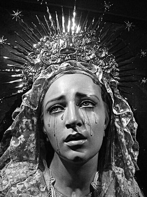 black and white photograph of a woman wearing a headdress with tears on her face