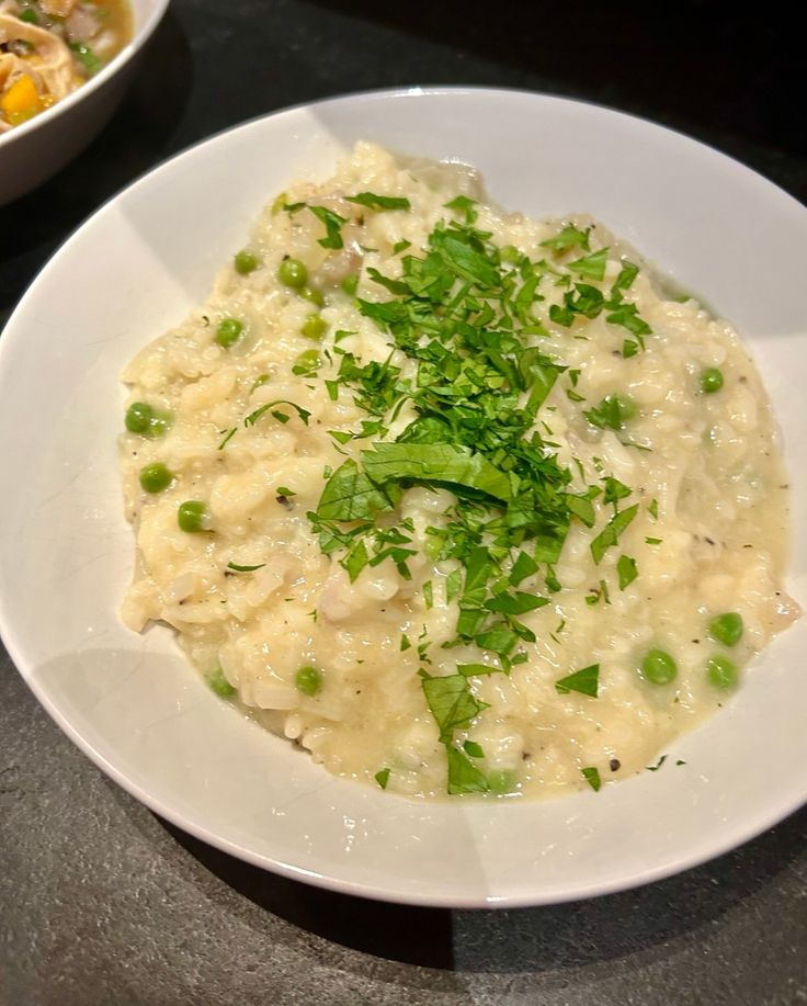 a white plate topped with rice and peas next to a bowl filled with broccoli