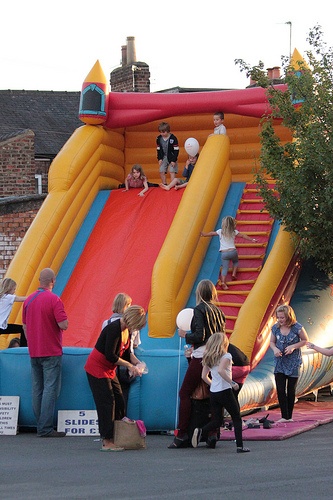 people are standing around in front of an inflatable slide