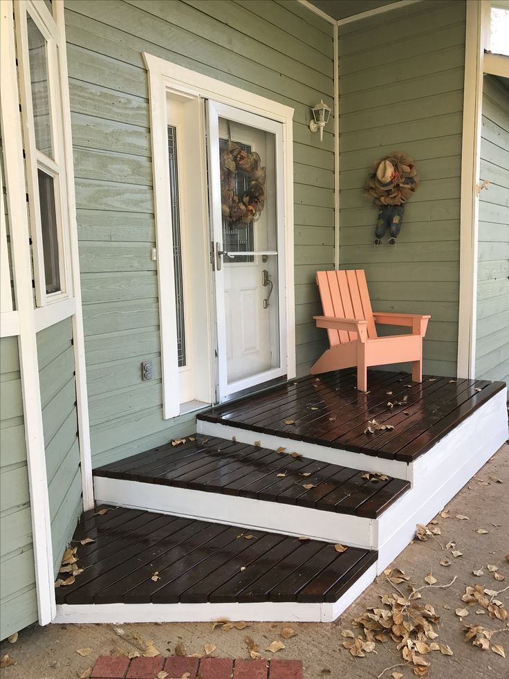 an orange chair sitting on top of a wooden porch