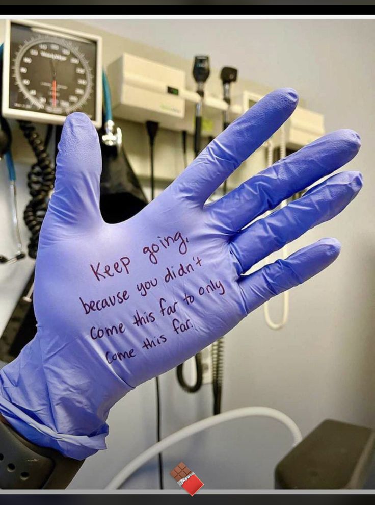 a glove that has writing on it in the middle of a room with other medical equipment