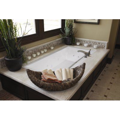 a bathroom with a large tub and plants on the counter