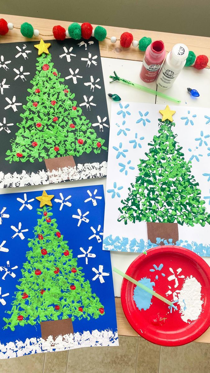 three paper plates with christmas trees on them next to crafting supplies and paintbrushes