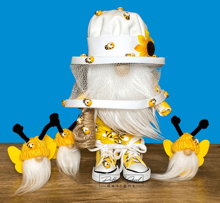 a white hat with yellow flowers on it and other items around it, sitting on top of a wooden table