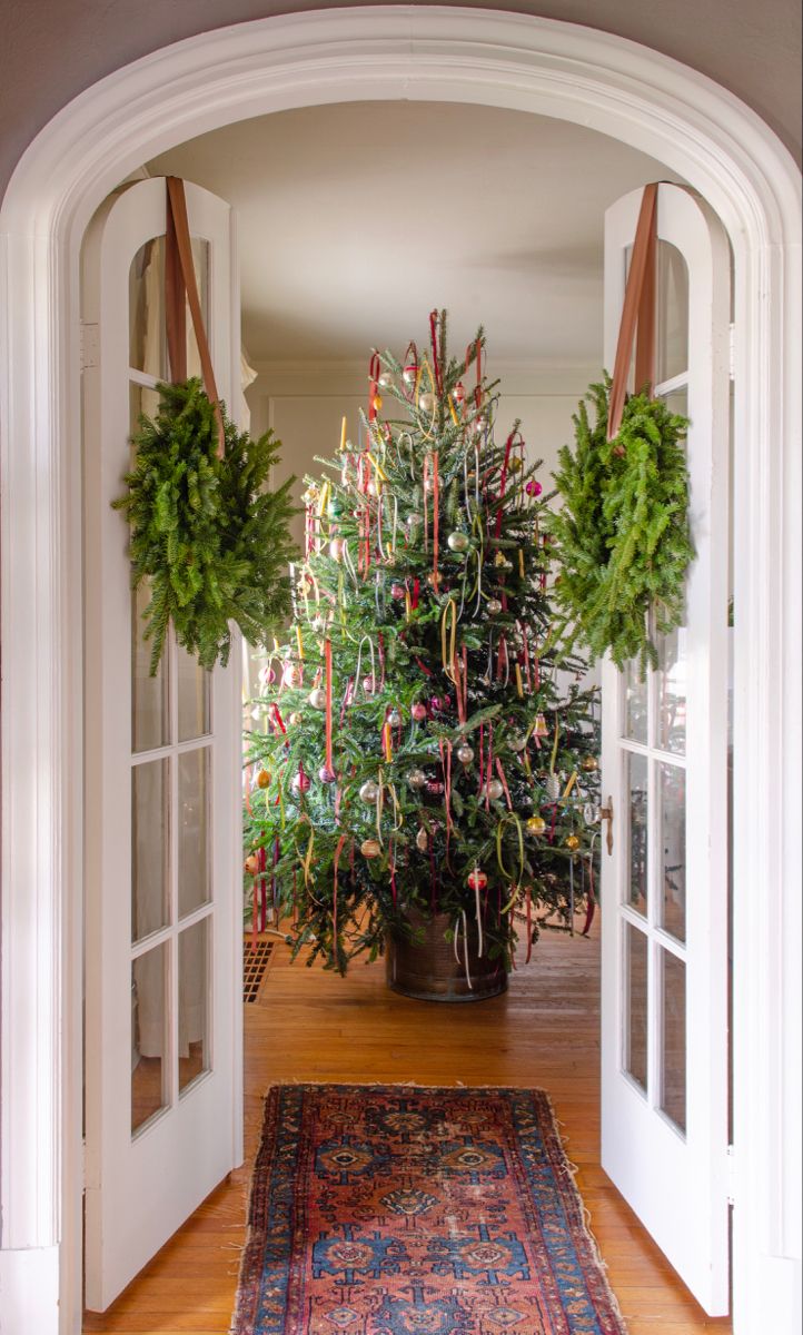 a christmas tree is in the middle of an archway with two wreaths hanging from it