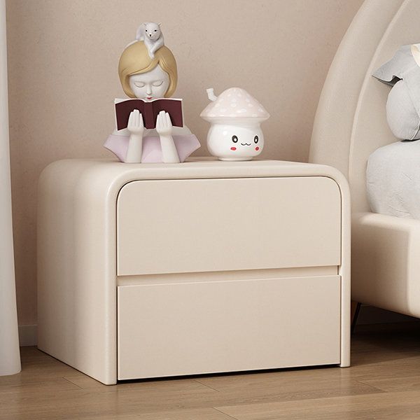 a white night stand with two little figurines on it