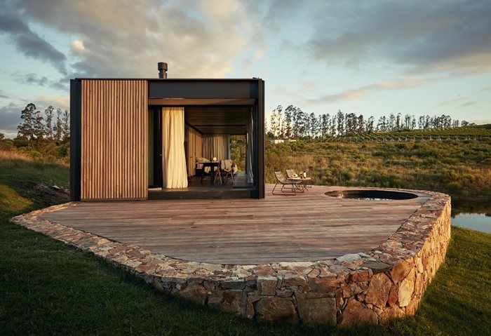 a wooden deck in front of a house with sliding glass doors on the outside and inside