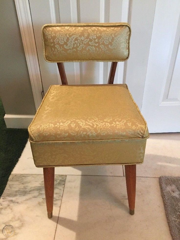 a gold chair sitting in front of a door with a rug on the floor next to it