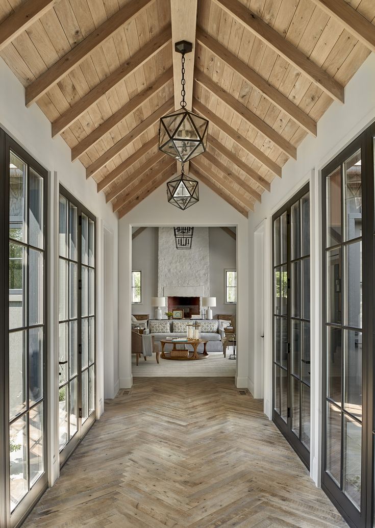 the inside of a house with wood flooring and large glass doors on both sides