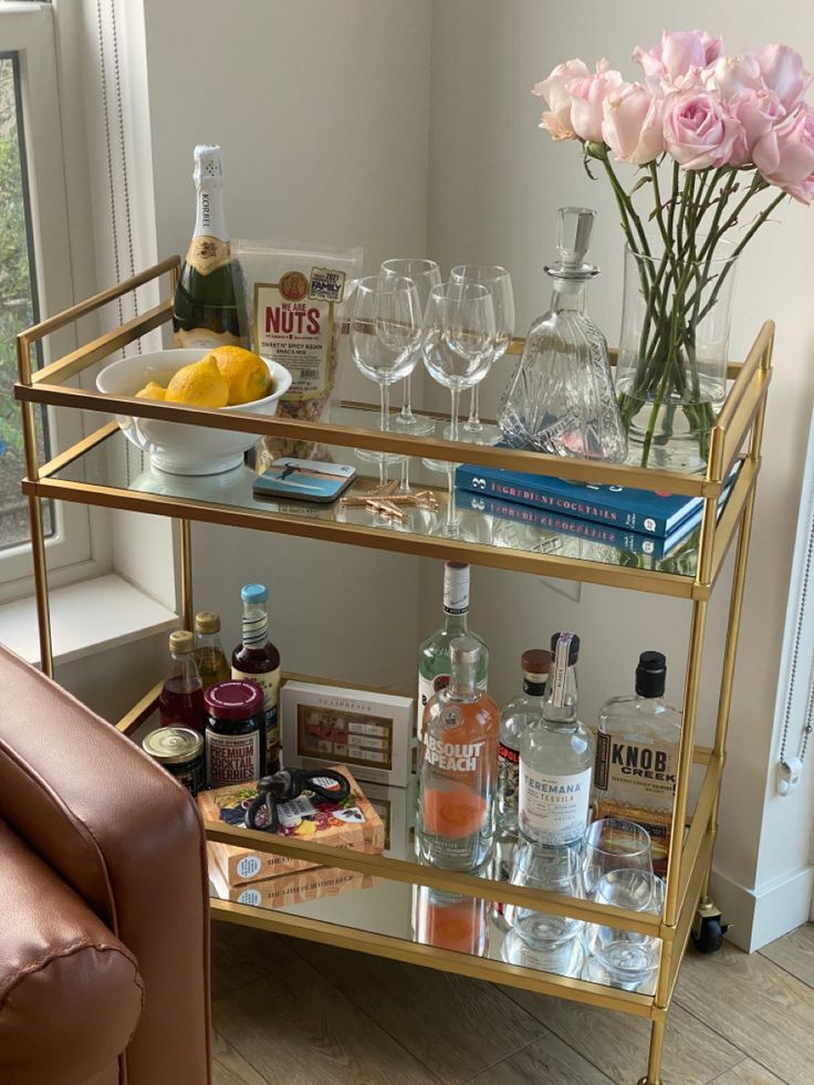 a gold bar cart filled with bottles and glasses