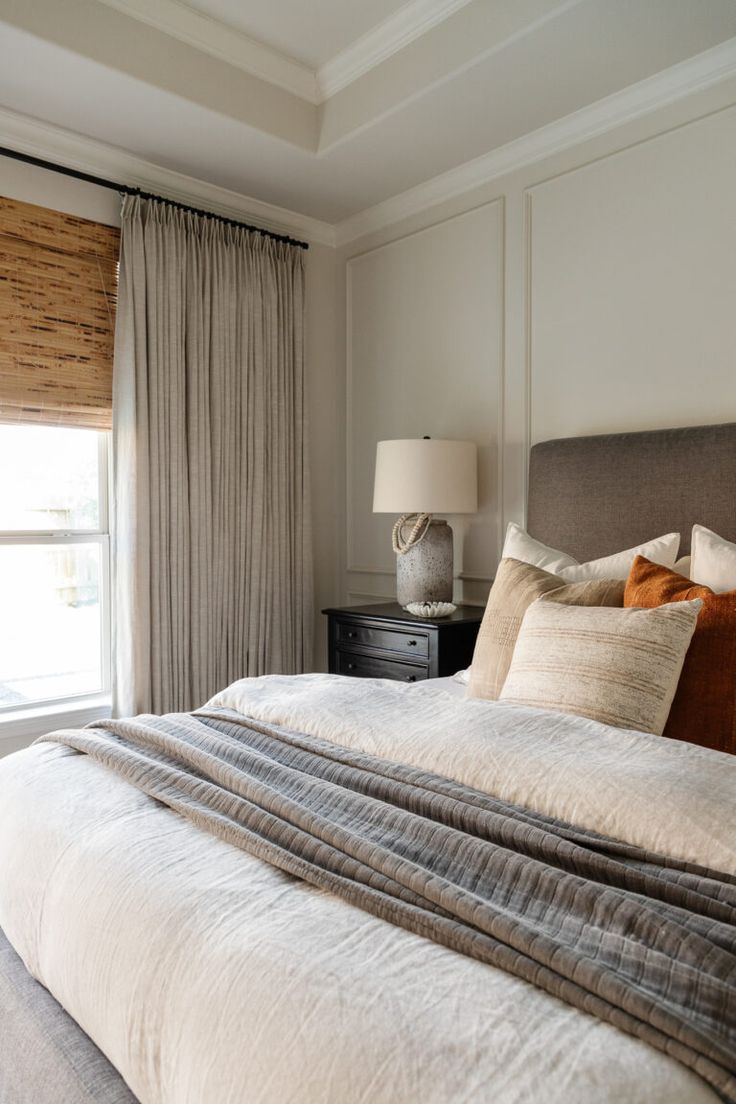 a large bed sitting next to a window in a bedroom