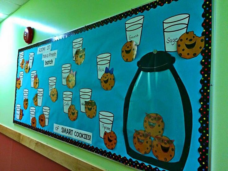 a bulletin board is hanging on the wall next to a table with cups and donuts