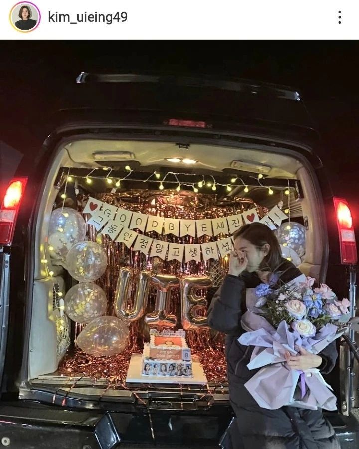 a woman standing in the back of a van with balloons and flowers on it's trunk