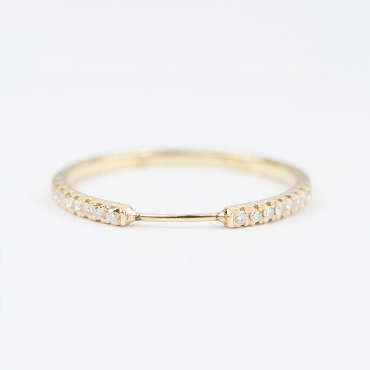 a yellow gold ring with three diamonds on the side and one diamond in the middle