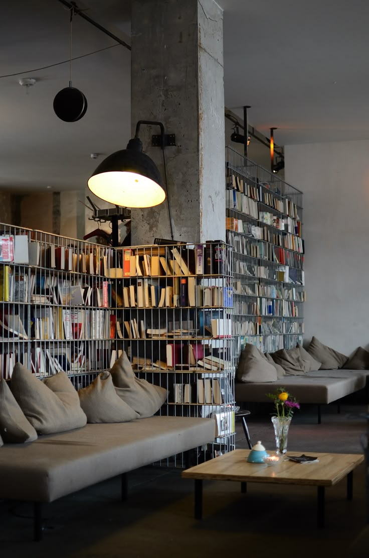 an image of a room with many books on the shelves and couches in it