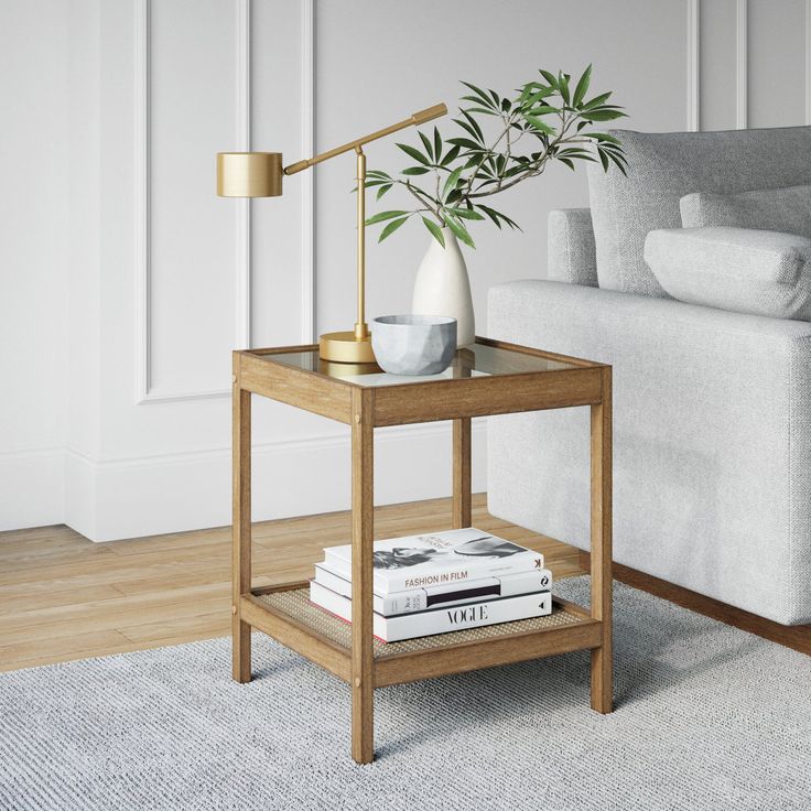 a living room with a couch, coffee table and books on the floor next to it