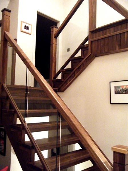 a wooden stair case with glass balconies on the bottom and handrails