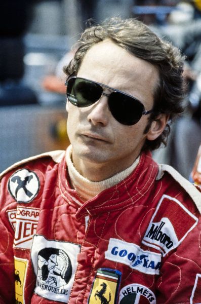 a man in a racing suit and sunglasses