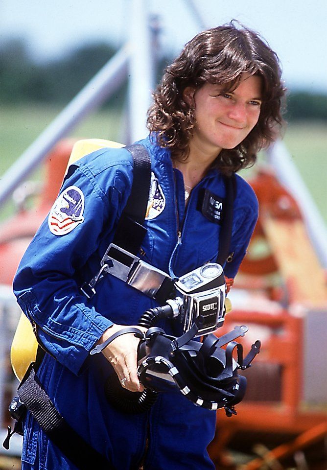 a woman in blue space suit holding a camera