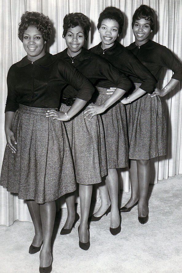 four women are standing in front of a curtain and posing for the camera with their hands on their hipss