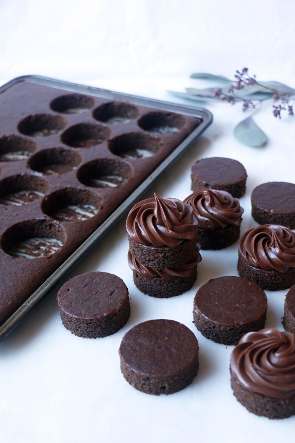 chocolate cupcakes and muffin holes sitting next to a baking tray on a table