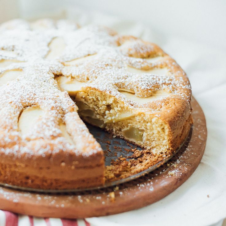 a cake that has been cut into pieces and is sitting on a wooden platter