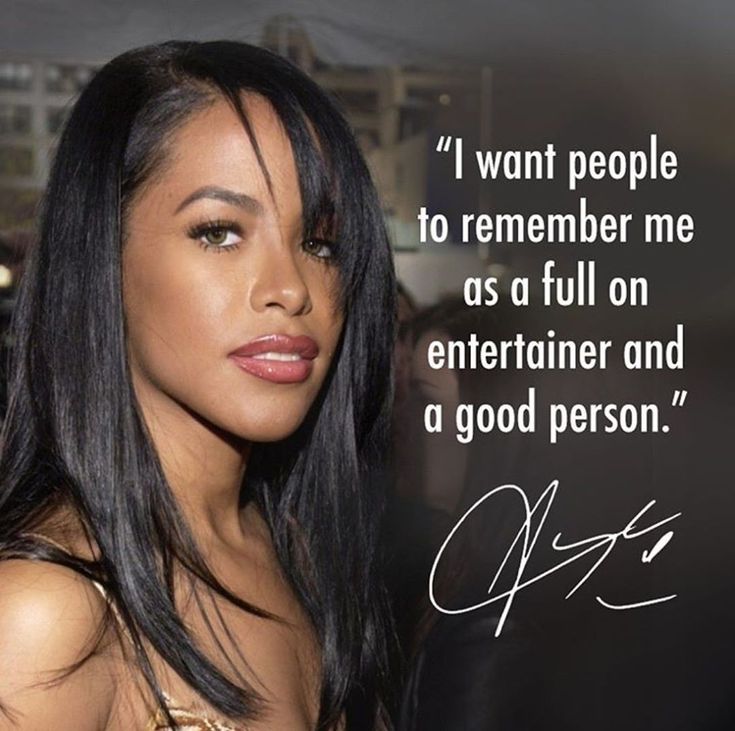 a woman with long black hair standing in front of a sign that says, i want people to remember me as a full on entertainer and a good person