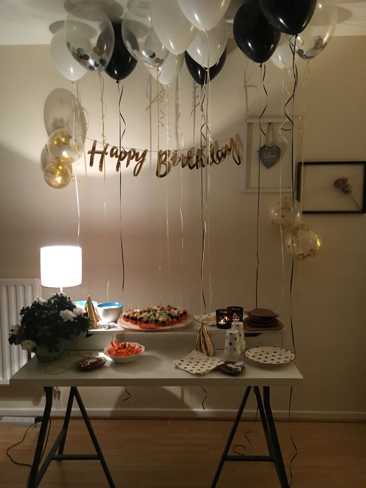 a table topped with balloons and cake on top of it