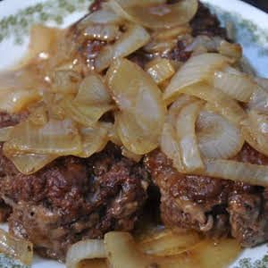 a close up of a plate of food with meat and onions