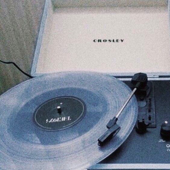 an old record player sitting on top of a table next to a box with the word crosley written on it