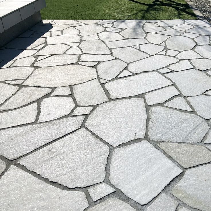 a stone patio with grass in the background